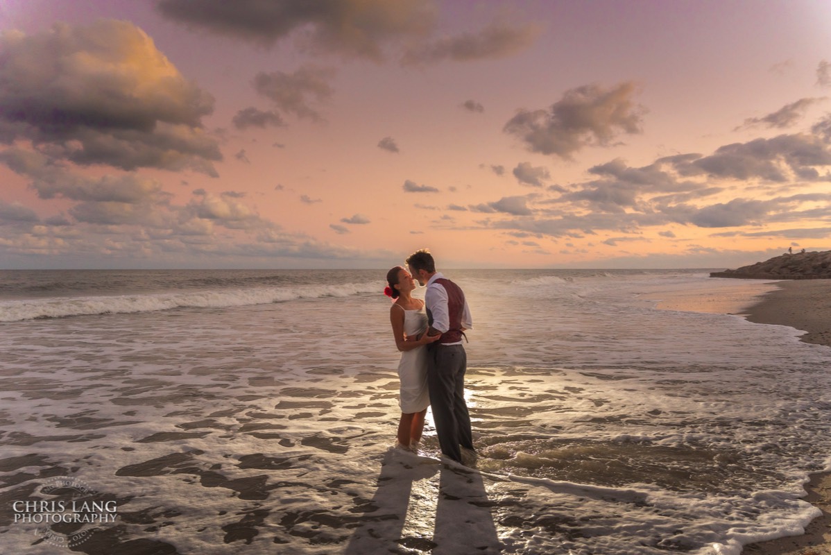 Fort Fisher Wedding Photographers - Ft Fisher Wedding Photography  - Bride & Groom standing in the waves at   Fort Fisher North Carolina -  Wedding Photography - Wedding Ideas - Bride - Groom - Wedding Dress - Chris Lang Photography- Popular wedding location - 