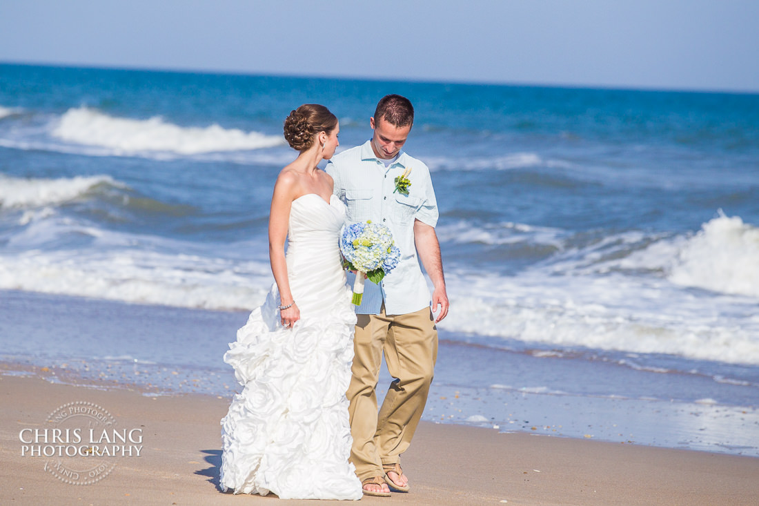 Bride and Groom walking ont he beach 