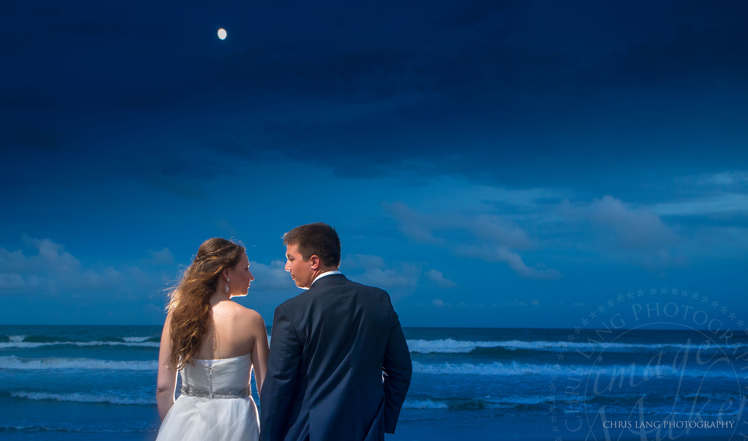 Wedding couple watching the moonrise over the Atlantice Ocean - Wrightsvile Beach Wedding Photographers