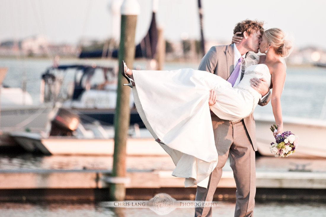 Groom picking up his bride and kissing her during a WIlmington NC Wedding - Wilmington NC Wedding Photography