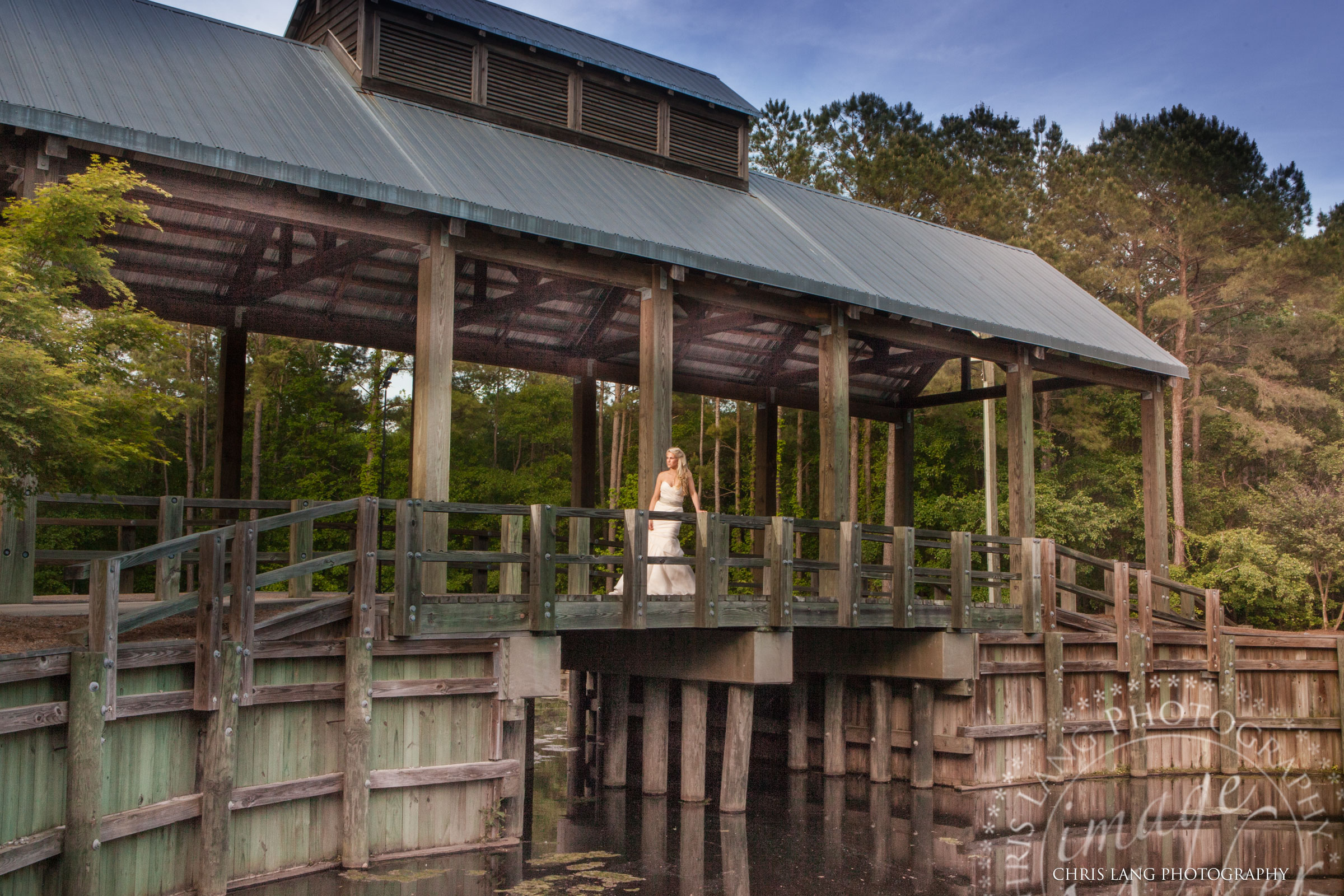 Image of Bride on the covered bridge at River Landing Country Club wallace NC - North Carolina Wedding Venues