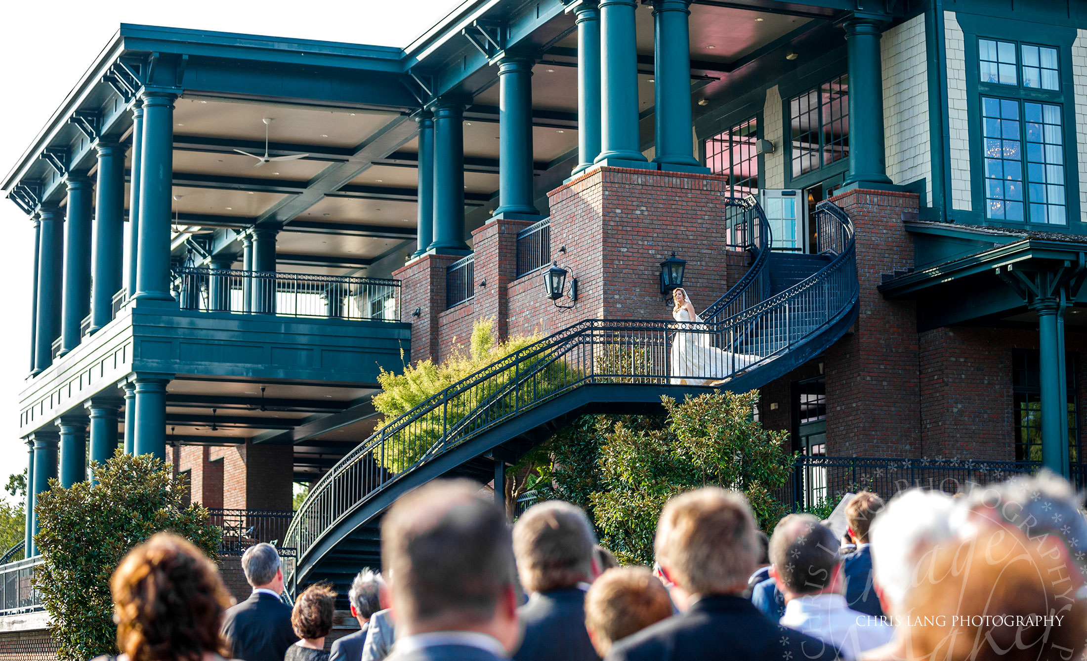 Lawn wedding at River Landing - Wallace NC - Image of Bride walking down the staircase entering the wedding ceremony on the lawn - Amazing Bridal Entrances