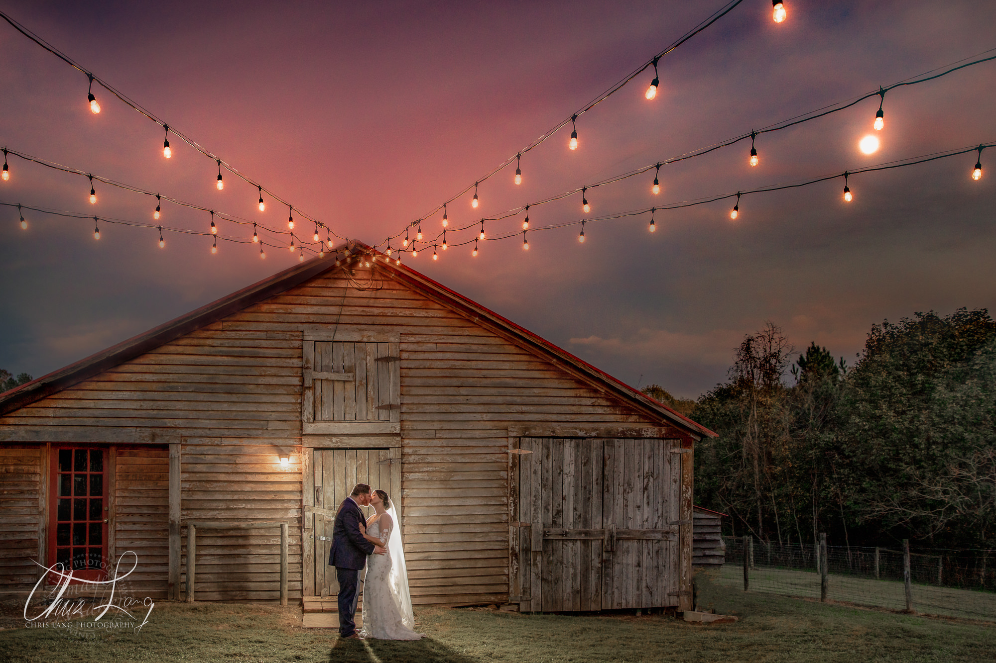 A creative wedding picture of a groom holding a lantern whilt kiissing his bride in her wedding dress. Wilmingotn NC Photographer