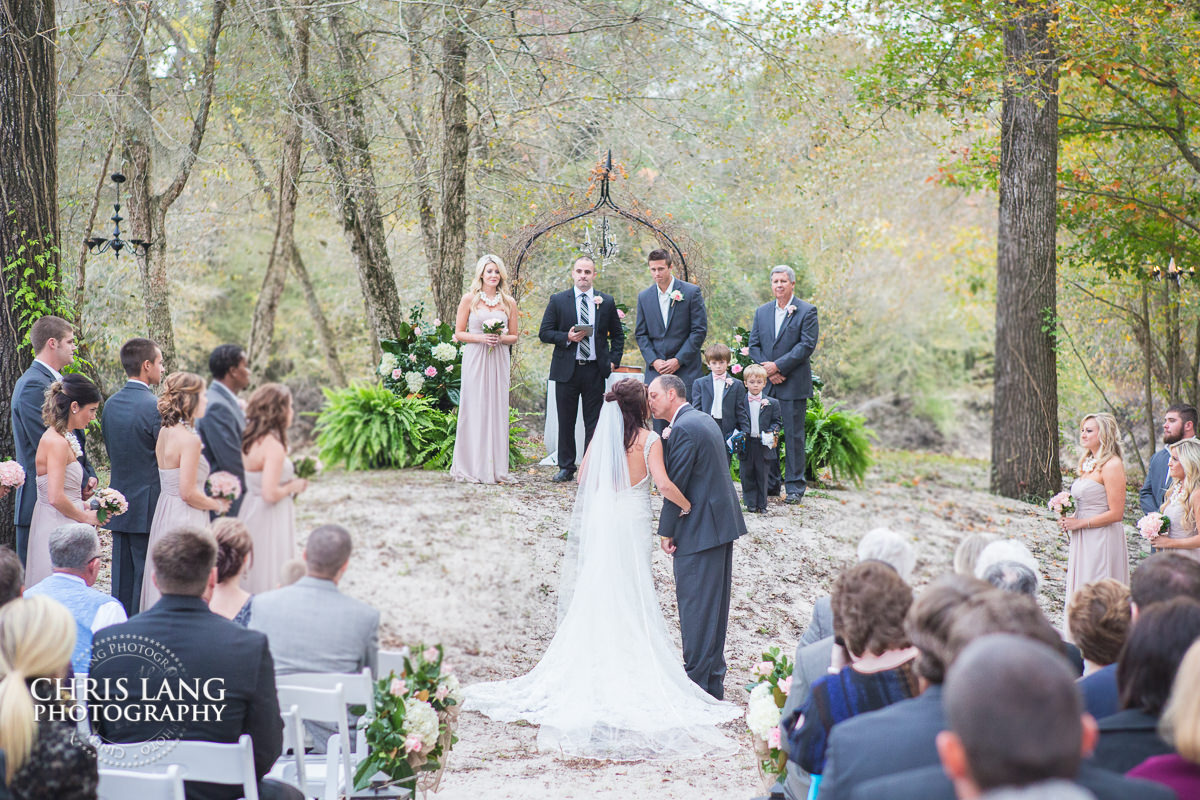 father kissing daughter at the end of the isle - wilmingotn nc wedding photography