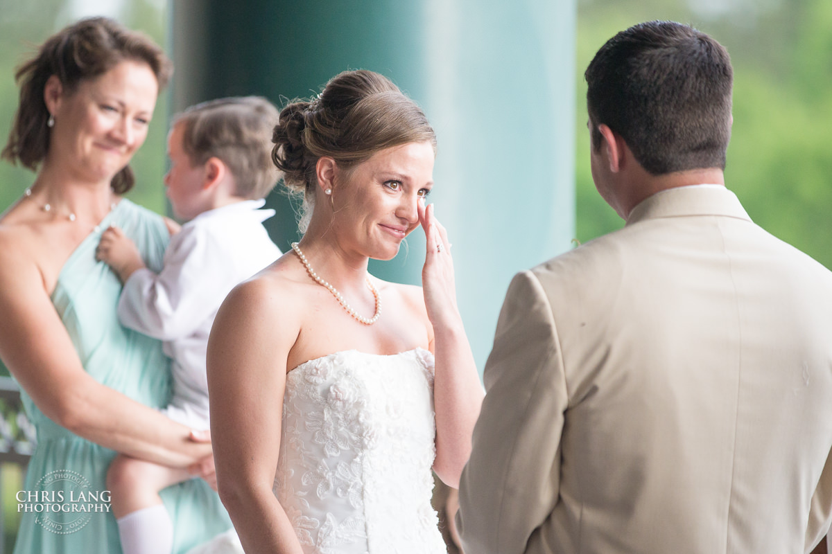 bride crying at alter exchanging vows - wilmingotn nc wedding photography - wedding ceremony photo - wedding ceremonies - bride - groom - bridal party - wedding ceremony photography - ideas