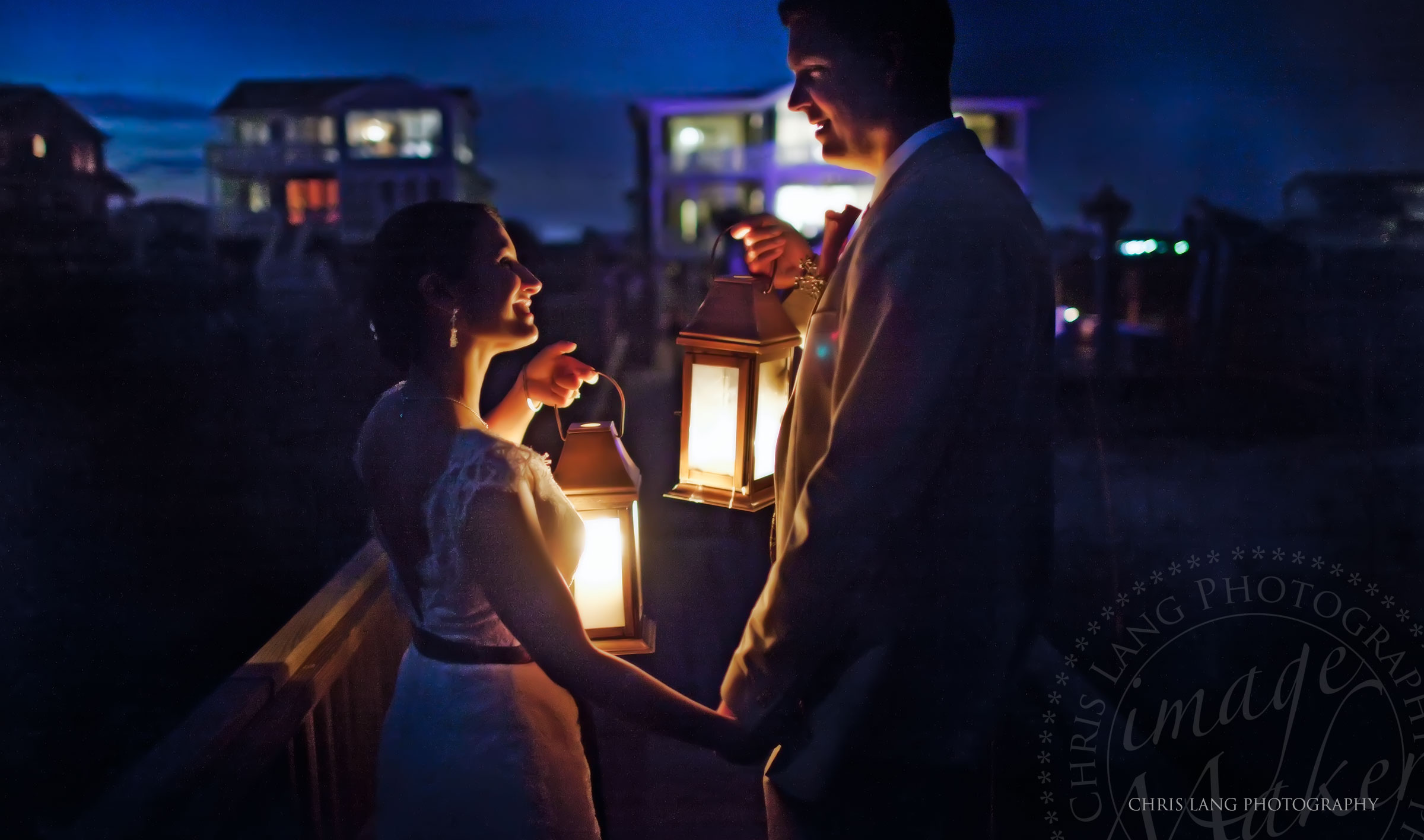 Wedding picture of bride and groom holding lanterns illuminating their faces on Wrightsville Beach NC. Wedding Picture Ideas.  