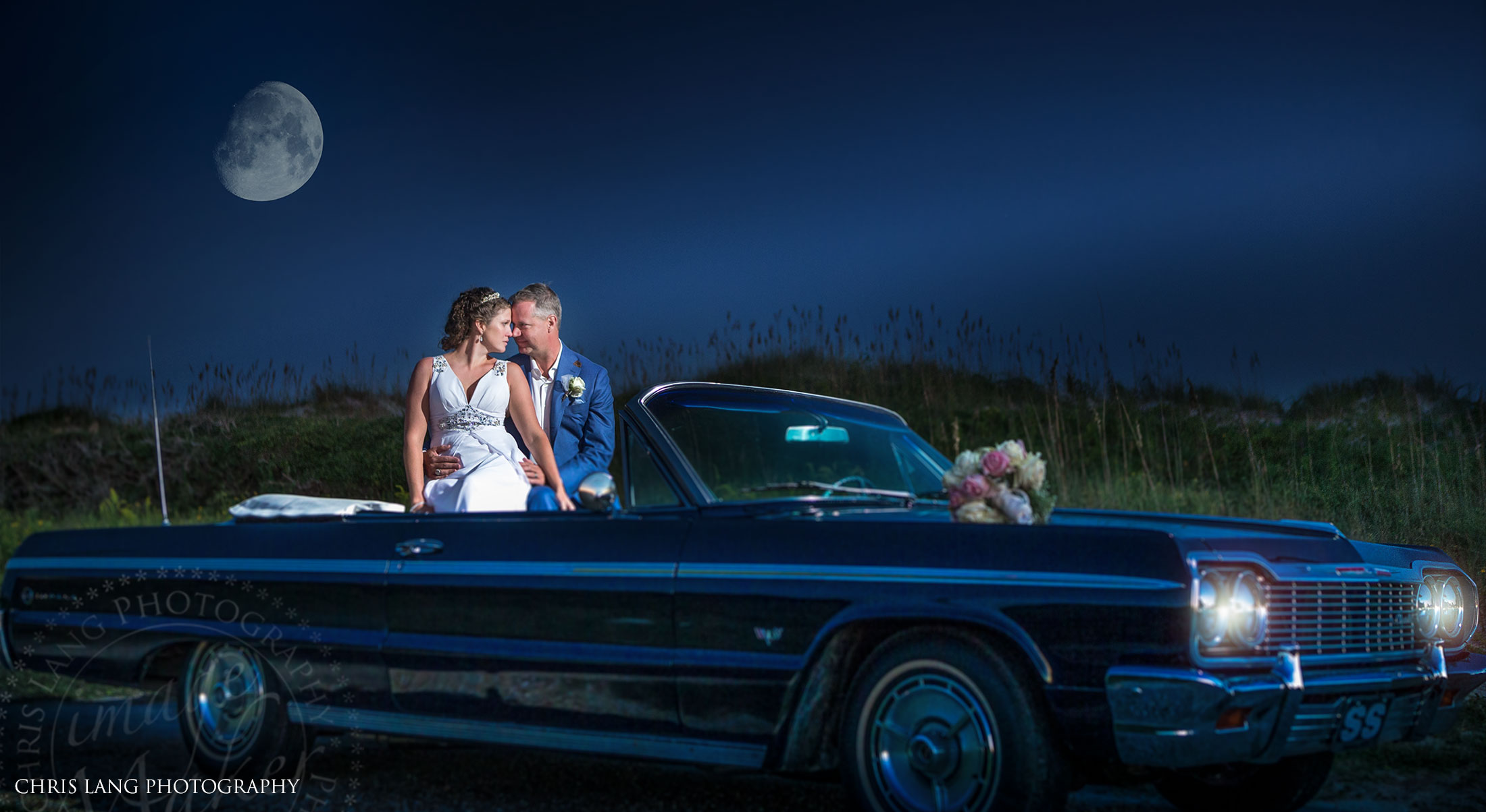 Bride & groom ina convertable car  at he beach watchingthe mooncome up over the Atlantic Ocean - Wilmington NC Photographers -