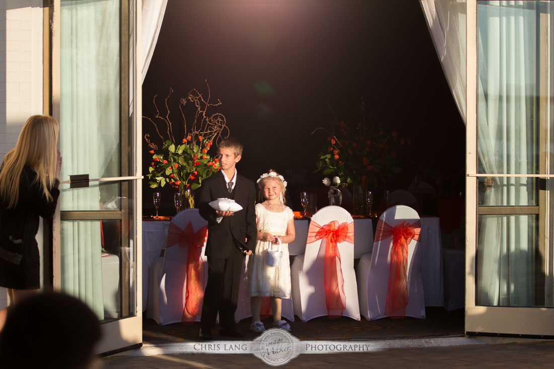 wedding photo at Hotel Ballast - image of flower gorl and ring bearer walking down the isle on the Cape Fear River front at Hotel Ballast - wedding picture - wilmington nc weddign venues