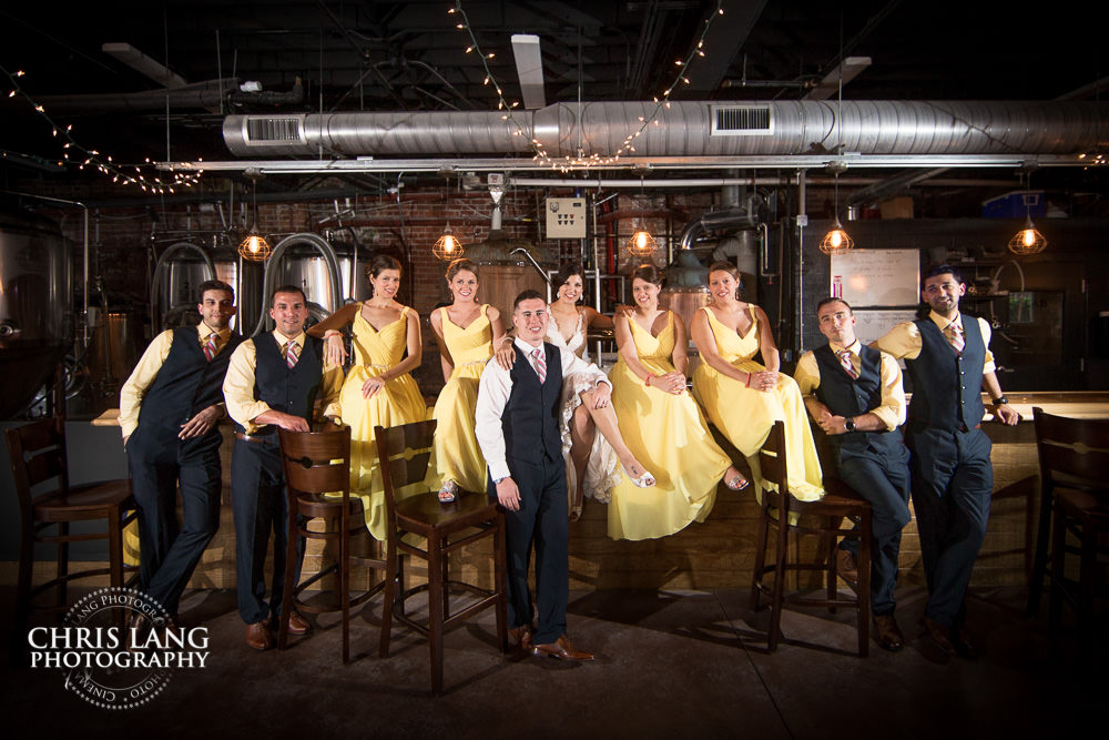 bridal party sitting on bar top - groomsman - bridesmaids - ironclad brewery - wedding photo - wedding photography - wedding & reception ideas - 