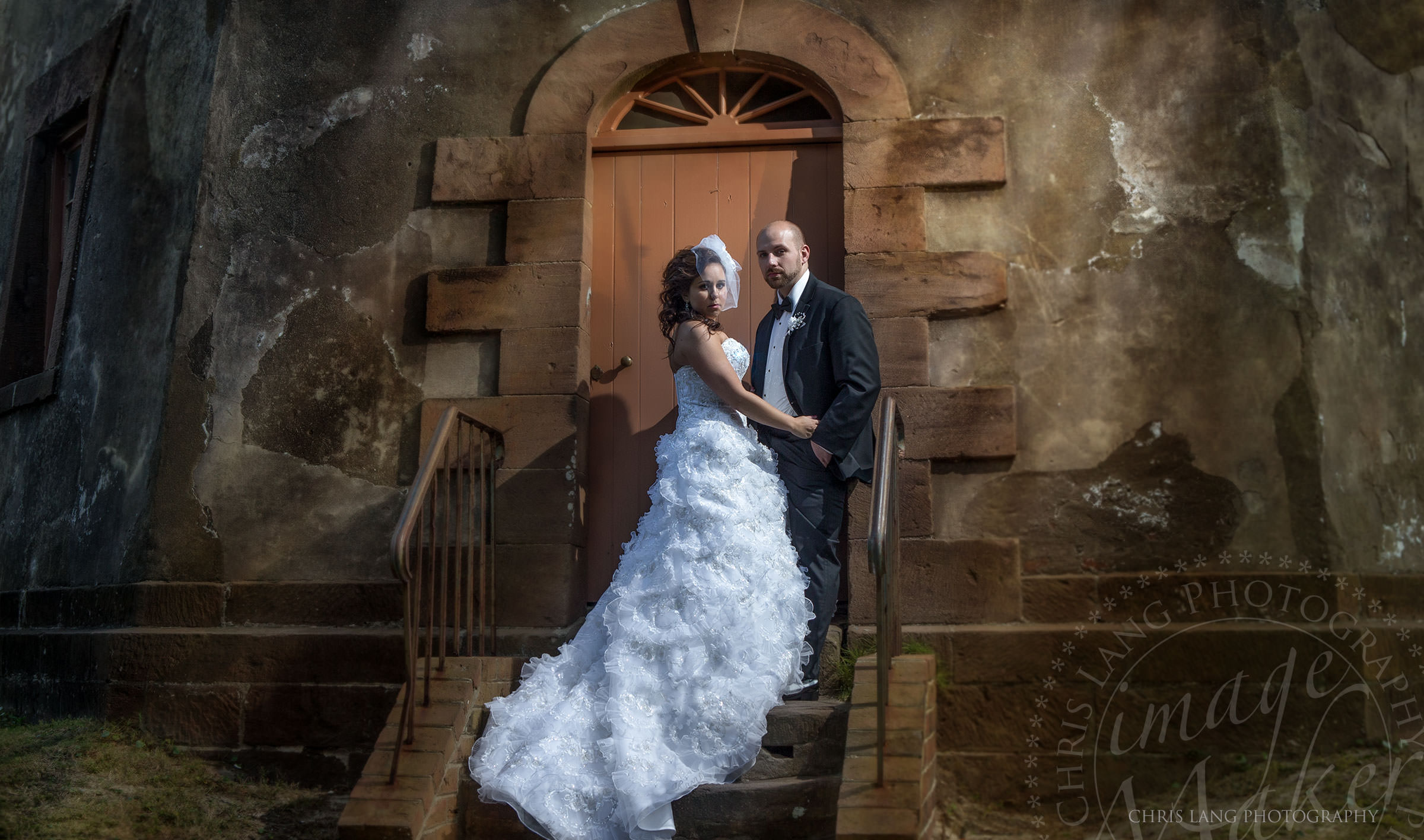 Wedding pictures of a bride and gromm at standing together holding hands during a wedding ceremony at the Bellamy Mansion at night. Wilmington NC Photographer