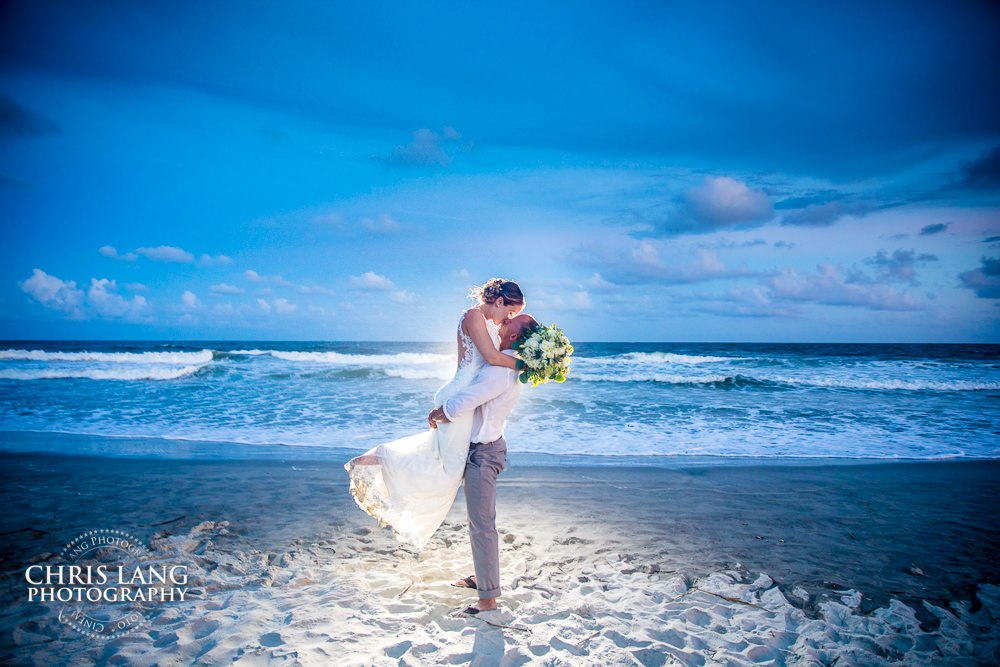 groom kissing bride at sunset - wrightsville beach north carolina wedding -  beach wedding photographer - destination weddings - 