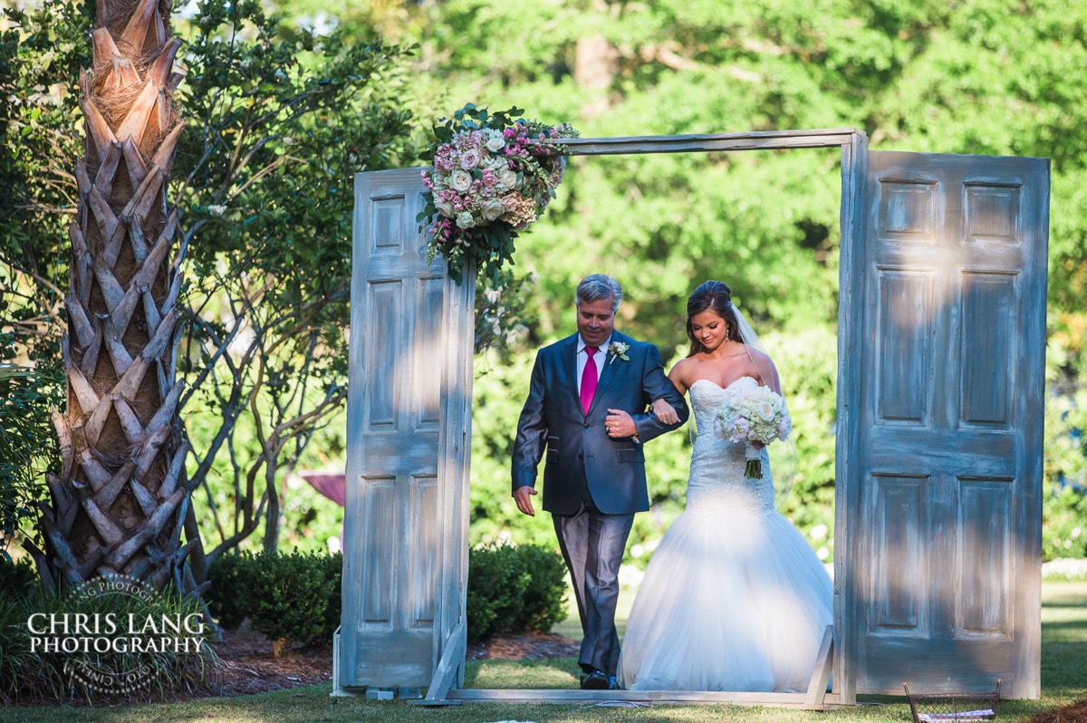 image of bride and father walking down the isle at Wrightsville Manor Wedding venue - outside weddings - Southeren Weddings - Wilmington NC wedding venues