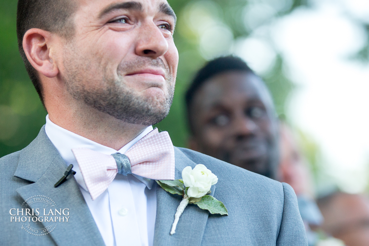 image of groom cryinf seeing his bride walk down the isle at Wrightsville Manor wedding venue in Wilmington NC - Chris Lang Photography